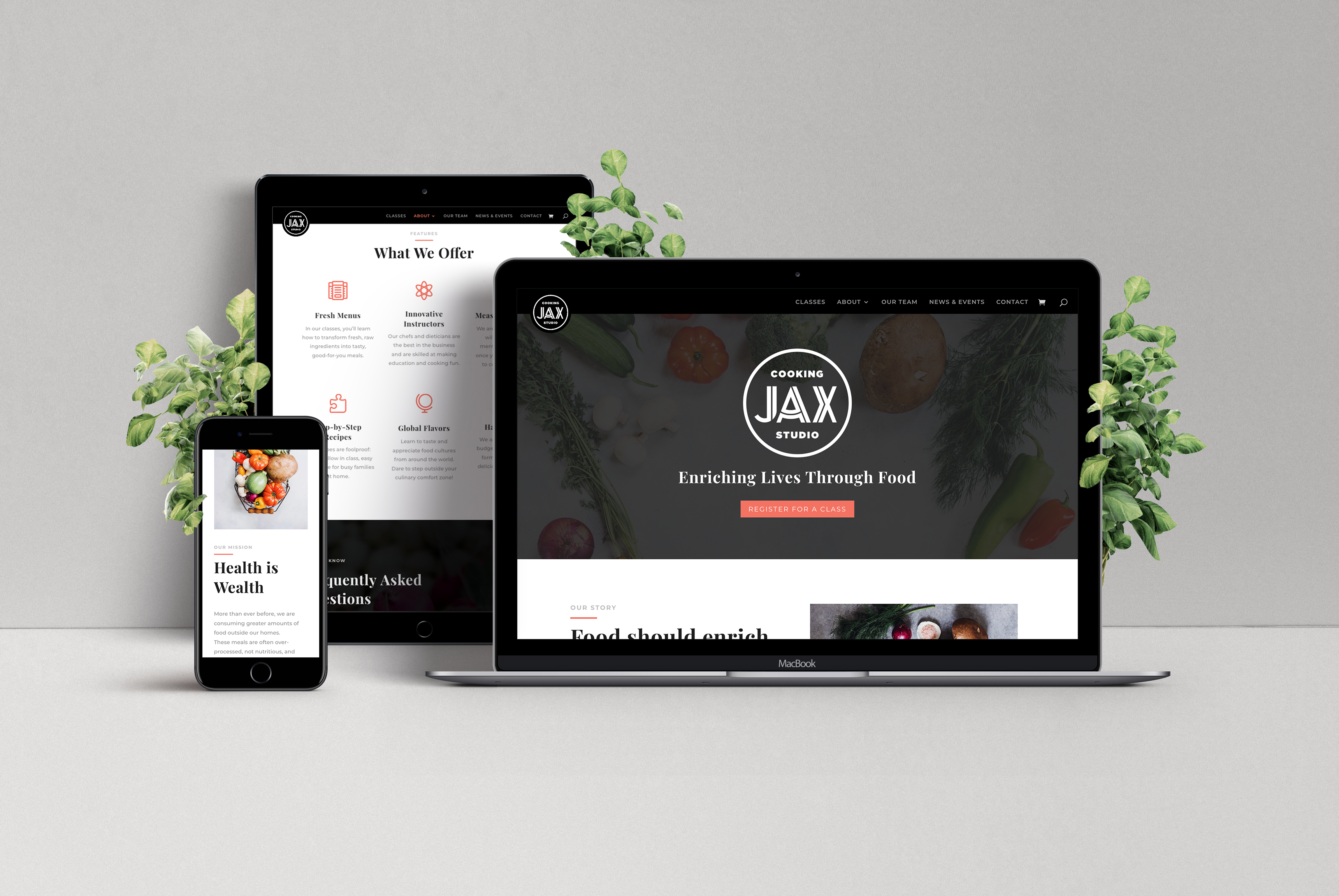 The website of JAX Cooking Studio displayed on an iPhone, iPad, and MacBook. The laptop features the logo and tagline (Enriching Lives Through Food) upon a dark gray background with vegetables.